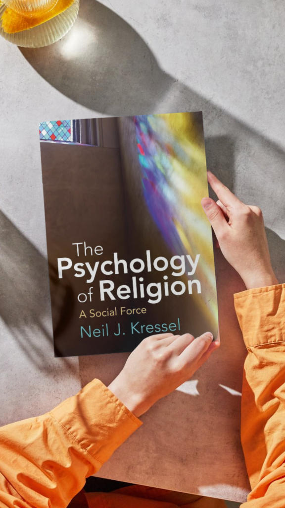 Hands are opening a copy of The Psychology of Religion A Social Force by Neil J. Kressel